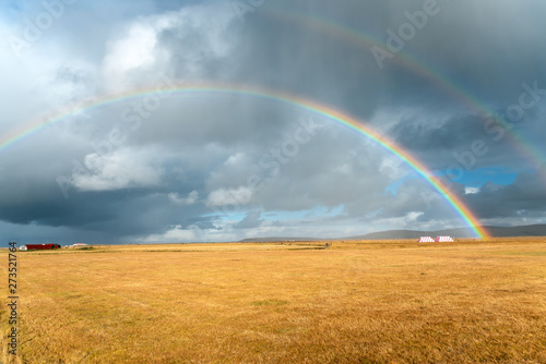 Rainbows and stormy sky over the countryside of Iceland in autumn