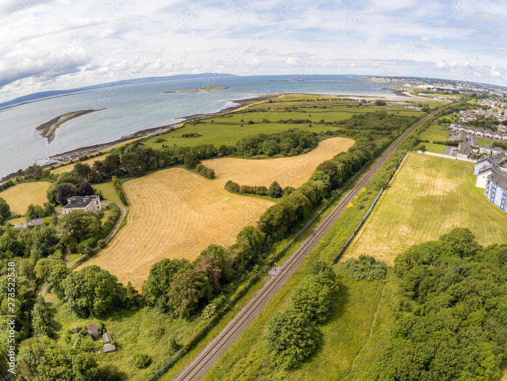 Train rail, fields and buildings in Galway bay