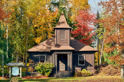 Very old log church at autumn. Oquossoc, Maine, USA. photo