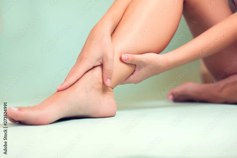 Woman feels strong foot pain isolated. People, healthcare and medicine concept Woman feels strong foot pain isolated. People, healthcare and medicine concept