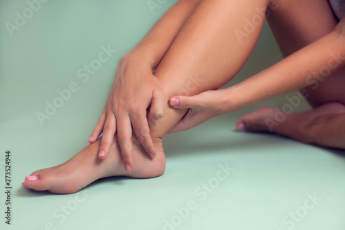 Woman feels strong foot pain isolated. People, healthcare and medicine concept © Aleksej