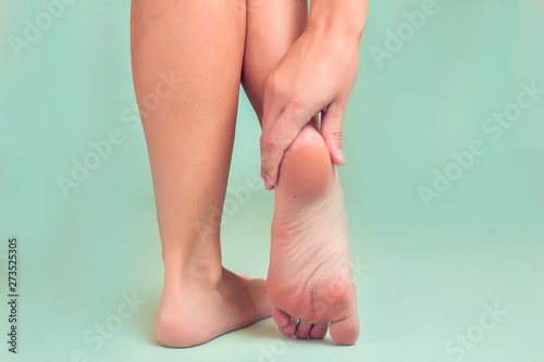Woman feels strong foot pain isolated. People, healthcare and medicine concept © Aleksej
