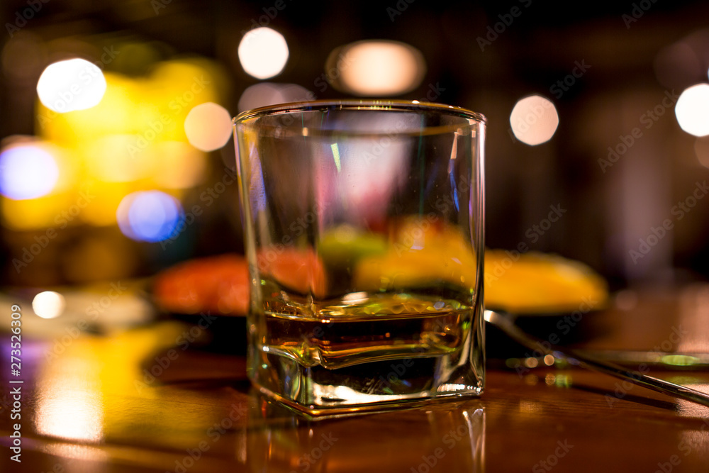 whiskey glass on the in a dark bar