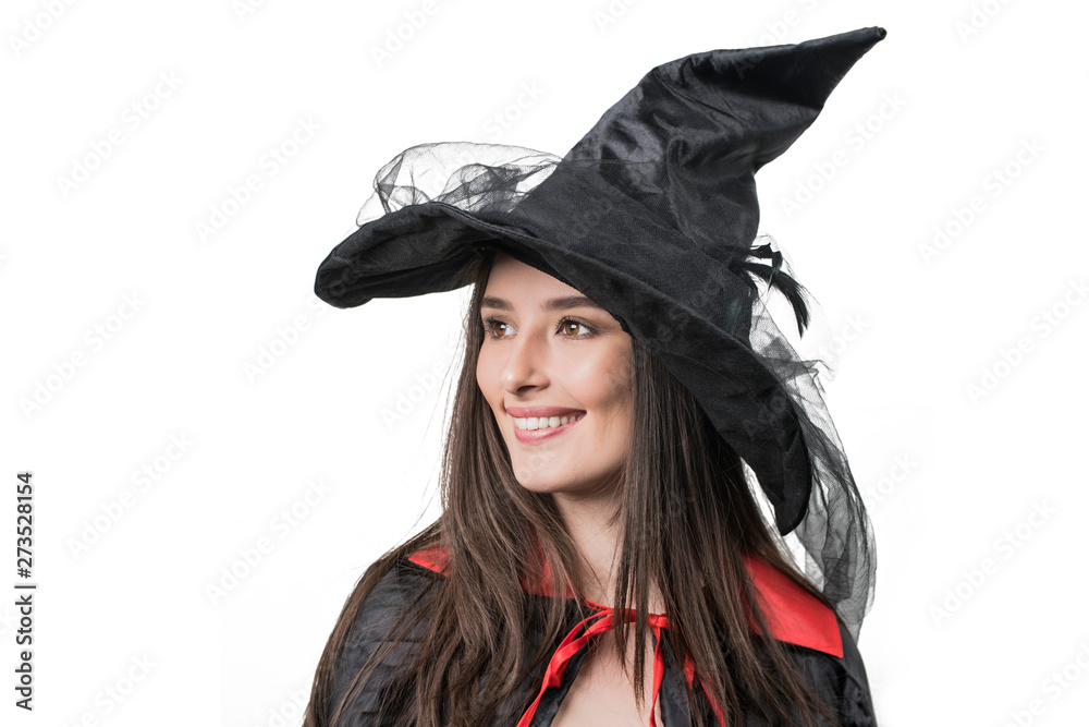 Happy gothic young woman in witch halloween costume with hat standing over white background Happy gothic young woman in witch halloween costume with hat standing over white background