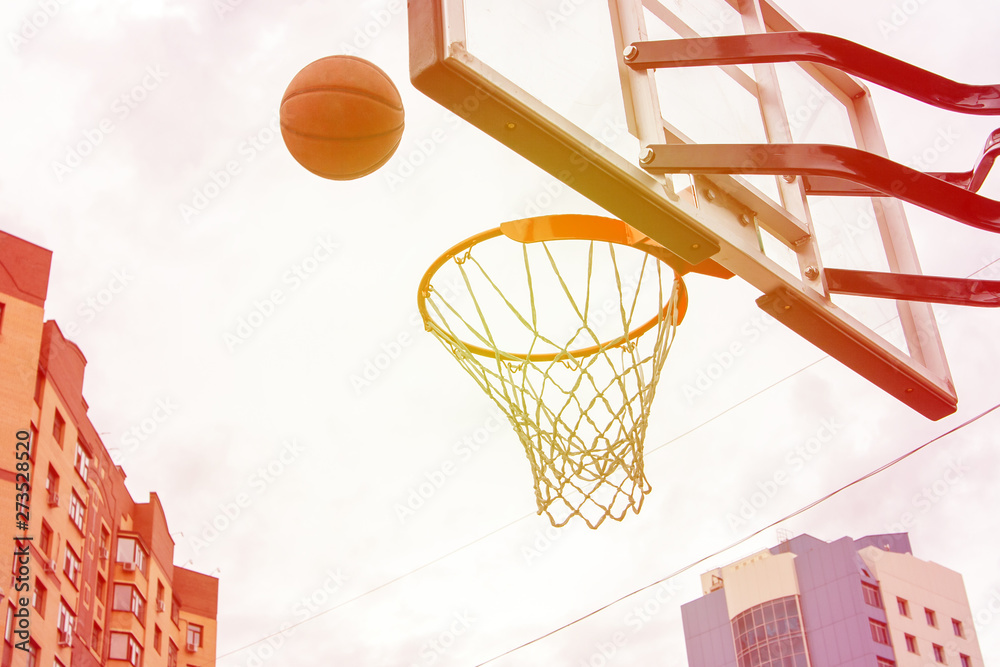 Basketball basket on the background of city houses. Street basketball.