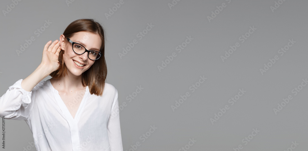 Portrait of young modern business woman. Smiling beautiful slim brunette with equal hair female business leader in casual wear expressing happy emotions. Gray background. Portrait of young modern business woman. Smiling beautiful slim brunette with equal hair female business leader in casual wear expressing happy emotions. Gray background.