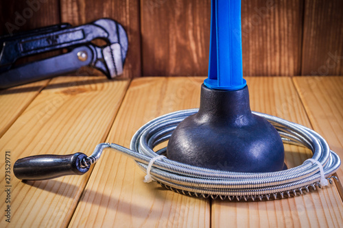 Clean plastic plunger with blue handle and cable on wooden background