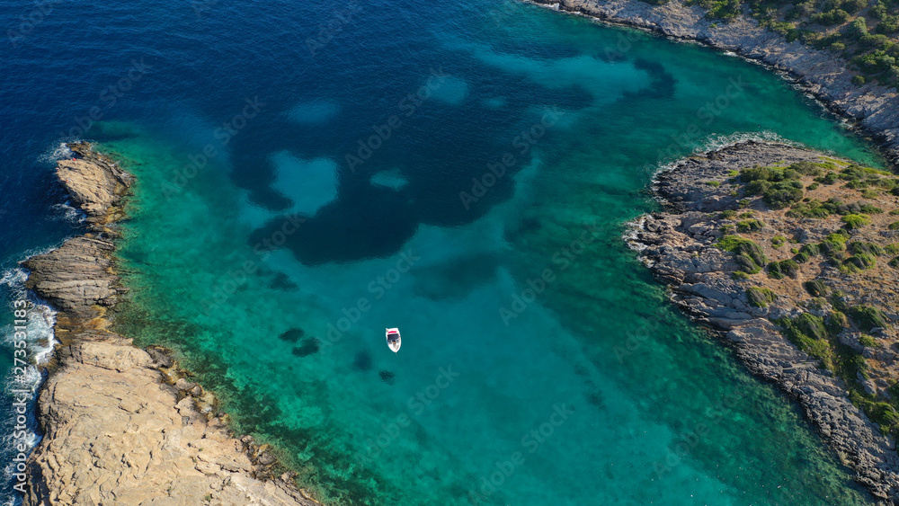 Aerial view of small islet of Ydrousa with turquoise and sapphire clear waters and only one mile distance from coast in Voula, Athens riviera, Attica, Greece
