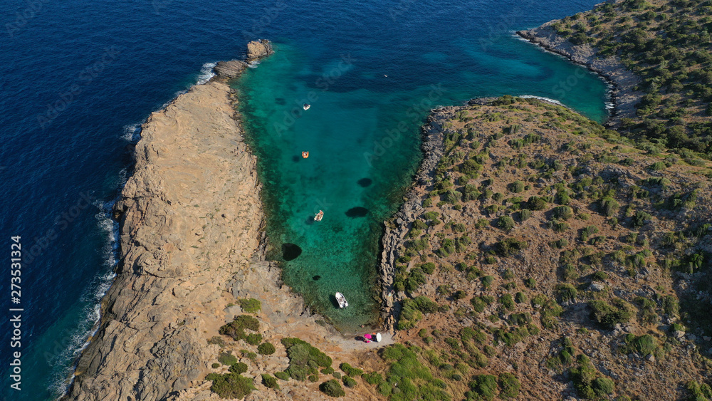 Aerial view of small islet of Ydrousa with turquoise and sapphire clear waters and only one mile distance from coast in Voula, Athens riviera, Attica, Greece