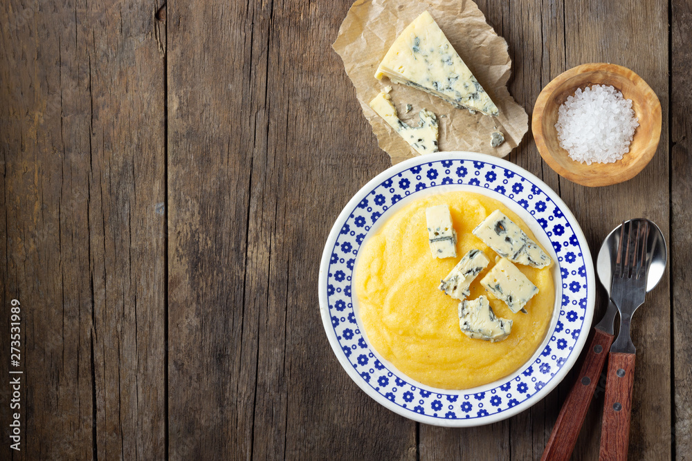 Italian food polenta with cheese gorgonzola on wooden table. Top view. Italian food polenta with cheese gorgonzola on wooden table. Top view.