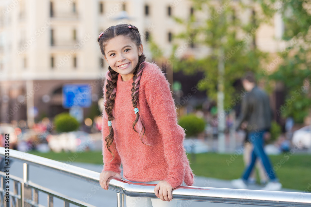 Little cutie. Adorable little kid with charming smile on summer day. Little child with brunette hair smiling in casual fashion style. Happy little girl with beauty look on urban background