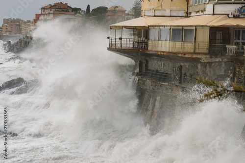 Forte mareggiata che colpisce una costruzione sulla costa photo