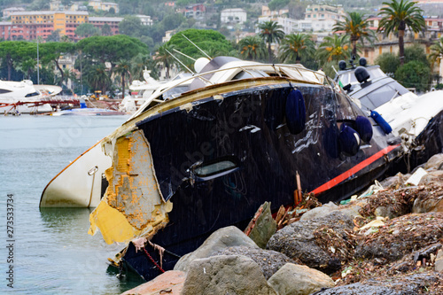 Barca distrutta da una forte mareggiata e incastrata sugli scogli photo