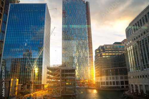 London, UK. Canary Wharf Banking and business area at sunset. Lights reflection in the dock water. 