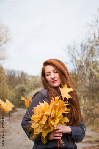 Portrait of young redhead woman in autumn field
