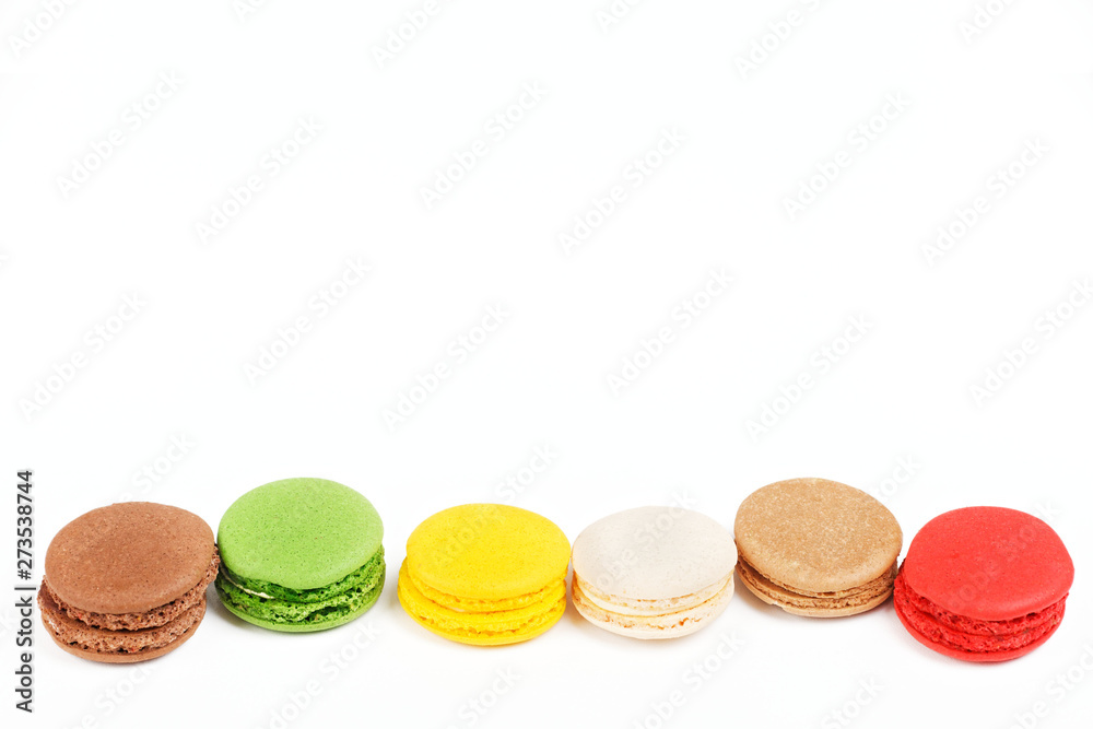 Macarons isolated on white background. Colored macaroons lined up in a row. On top of the copy space. Macarons isolated on white background. Colored macaroons lined up in a row. On top of the copy space.