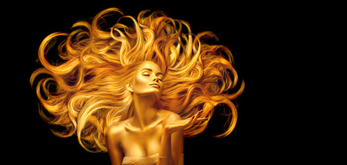 Tableau sur plexiglas Femme Golden beauty woman. Sexy model girl with golden makeup and long hair pointing hand over black. Metallic gold glowing skin and fluttering hair  © Subbotina Anna