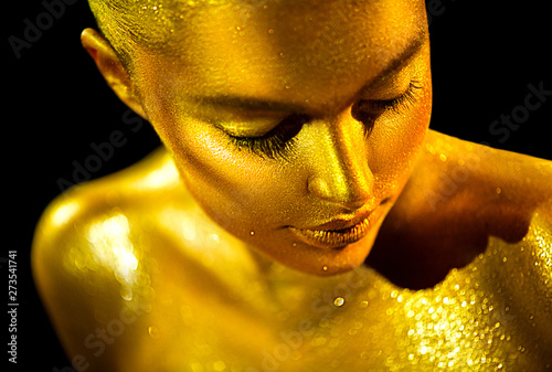 Beauty sexy woman with golden skin. Fashion art portrait closeup. Model girl with shiny golden professional makeup. Gold jewellery © Subbotina Anna