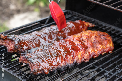 Bilde på lerret Pork ribs cooking on barbecue grill for summer outdoor party.