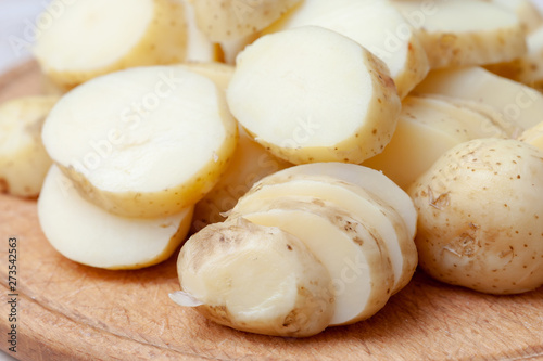 sliced boiled potatoes on the kitchen board. ingredient for the dish.