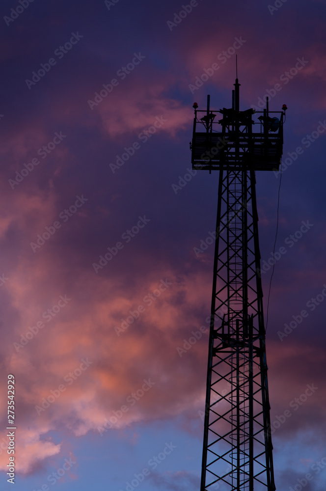 Silhouette mast lighting against the evening sky