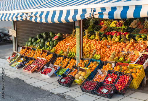 local neighborhood fresh organic fruit market counters with fresh colorful fruits on display in greece