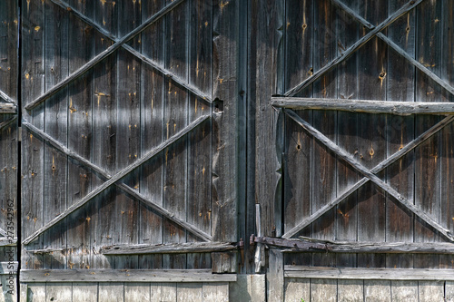 Old wooden door to the barn, gray old wooden boards.