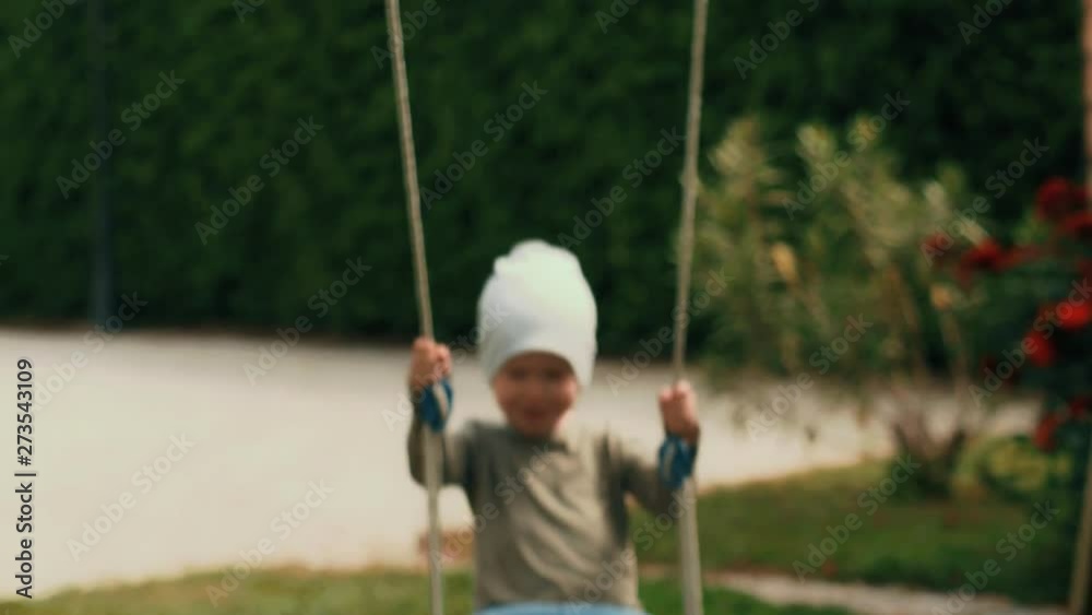 Happy active little boy enjoying swinging on swing positive child smiling at park playground Happy active little boy enjoying swinging on swing positive child smiling at park playground