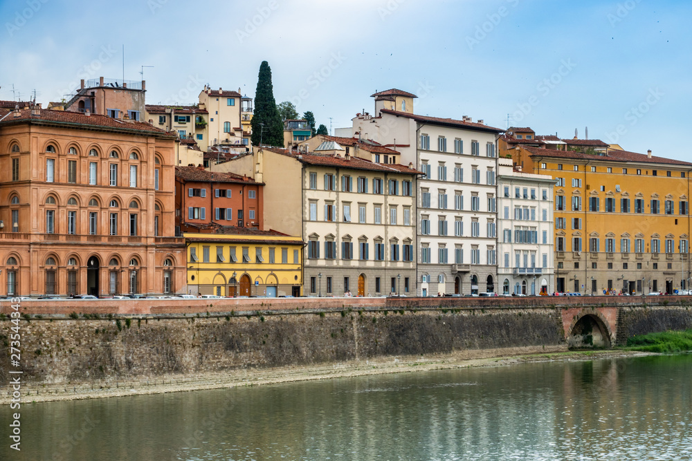 Colorful buildings line the banks of the Arno River in Florence, Italy.