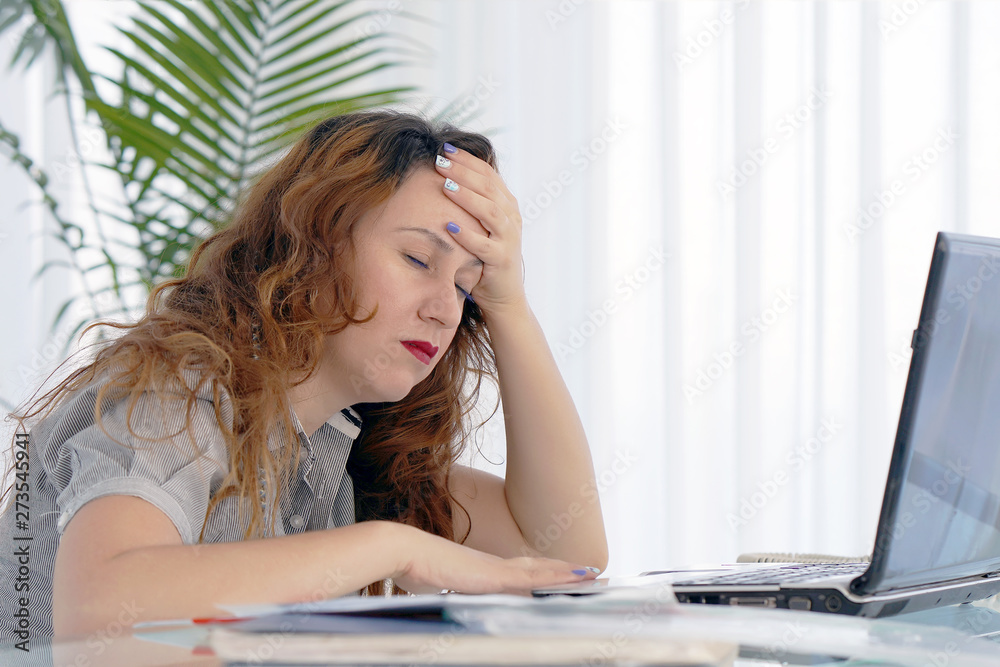 Social worker working at her desk suffering from headache migraine pain. Woman hospital secretary sitting at her workplace. Health problem, stress and depression. Female holds head with hand.
