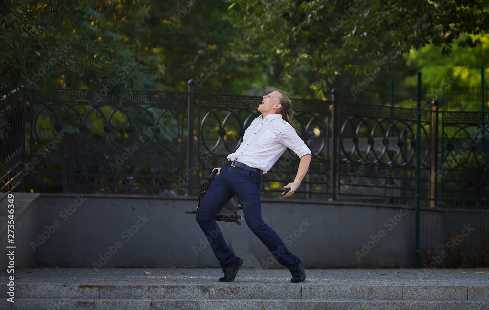 Happy businessman jumping with cityscape background. The best day. Young  man in formal wear keeping arms raised and expressing positivity while standing outdoors. Flexibility and grace in business