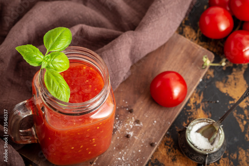 Organic homemade tomato juice in mason jar with basil and salt