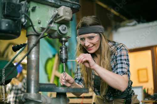 woman wearing safety glasses working in a workshop © aerogondo