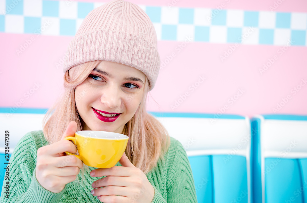 Young woman wearing casual cap drinking tea in cafe Young woman wearing casual cap drinking tea in cafe