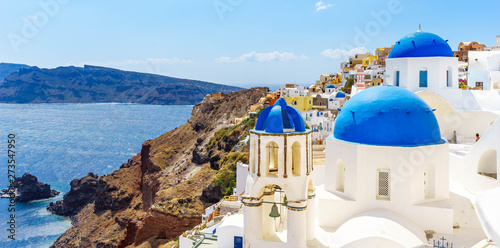 Fototapeta Naklejka Na Ścianę i Meble -  Oia town on Santorini island, Greece. Traditional and famous houses and churches with blue domes over the Caldera, Aegean sea