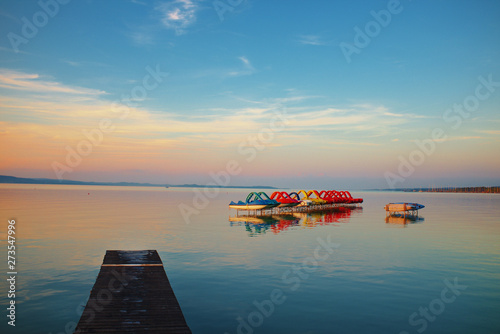 Sunset over lake Balaton with pedalos anda pier in Hungary photo