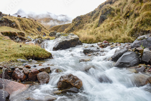 An icy stream flows with glacial waters from the mountains of Cusco s Sacred Valley. Peru