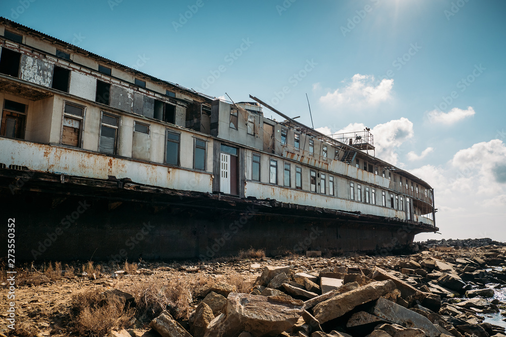 Obraz premium Old abandoned rusted ship aground after shipwreck accident in coast on sand beach
