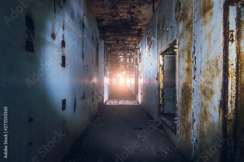 Creepy corridor in abandoned nuclear power plant with light in end © DedMityay