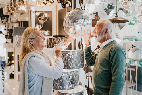 Senior couple in home lighting store shoosing shandelier for their home photo