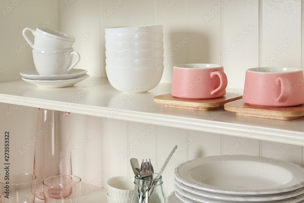 White shelving unit with set of dishware White shelving unit with set of dishware