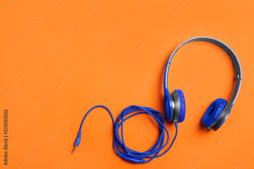 Stylish headphones on color background, top view. Space for text Stylish headphones on color background, top view. Space for text