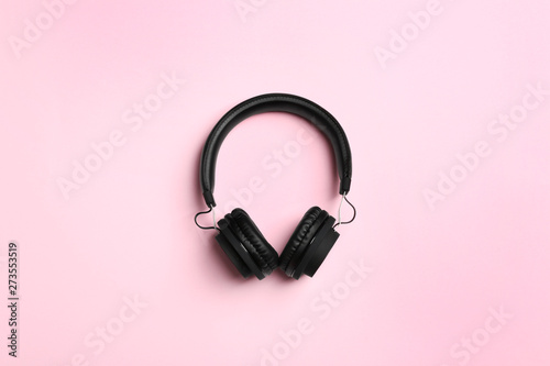 Stylish headphones on color background, top view