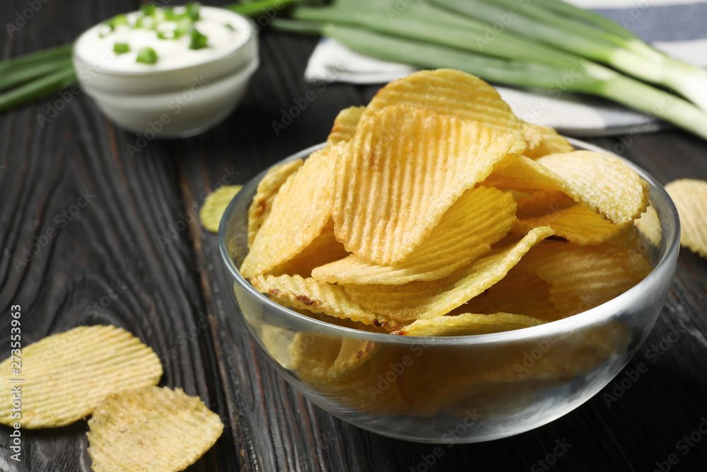 Bowl with potato chips on wooden table, closeup. Space for text Bowl with potato chips on wooden table, closeup. Space for text