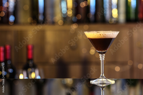 Glass of delicious Espresso Martini on bar counter, space for text. Alcohol cocktail