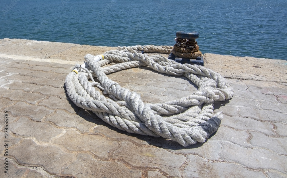 Fototapeta premium Thick white mooring rope closeup on empty mooring place