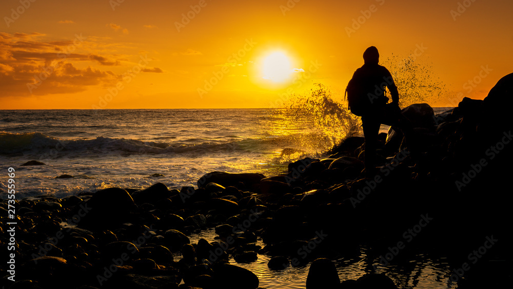 Man on coast at sunrise