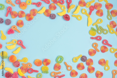 Fototapeta Naklejka Na Ścianę i Meble -  Blue paper background with sugary jellies. Place for your text. Cozy sweet background