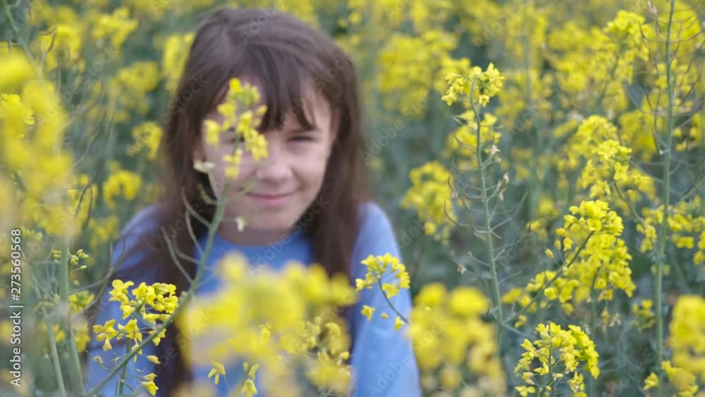 Happy teen girl in yellow canola colors. A young girl in a blooming yellow field. Happy teen girl in yellow canola colors. A young girl in a blooming yellow field.