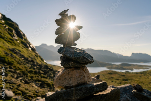 Man in red hat sitting on a rock looking at the beach